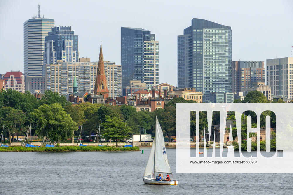 Sail boat in Boston Harbor, Boston against the cityscape of Back Bay Boston, Massachusetts, USA from across the Charles River Boston Massachusetts USA
