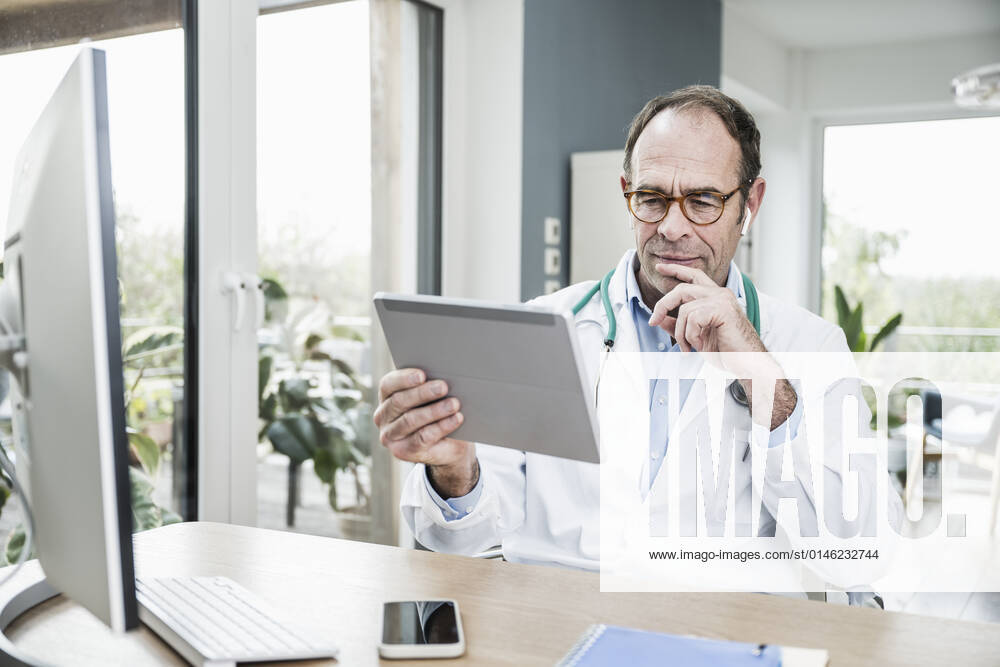 Doctor looking at tablet PC in hospital model released property released, UUF25256