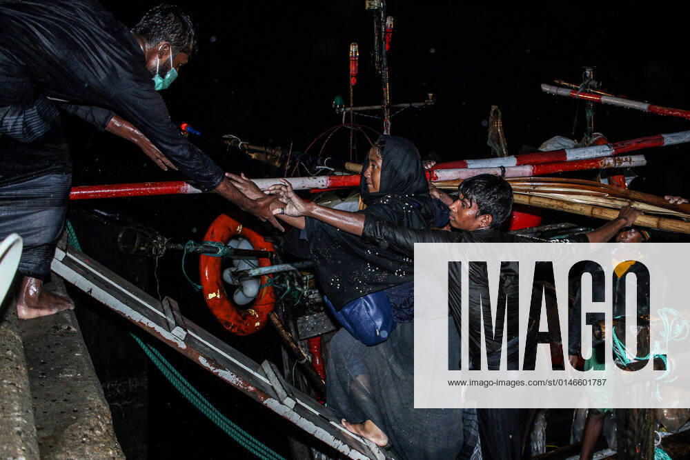 (211231) -- ACEH, Dec. 31, 2021 -- Rohingya refugees walk from a wooden boat as Indonesian officials conduct evacuation at the Krueng Geukueh port in Lhokseumawe, Aceh, Indonesia, Dec. 31, 2021. Indonesia s navy has rescued more than 100 Rohingya asylum seekers who have been adrift on a sinking boat off the country s western coast, bringing them to a temporary place. (Photo by Xinhua) INDONESIA-ACEH-ROHINGYA-REFUGEES-EVACUATION FachrulxReza