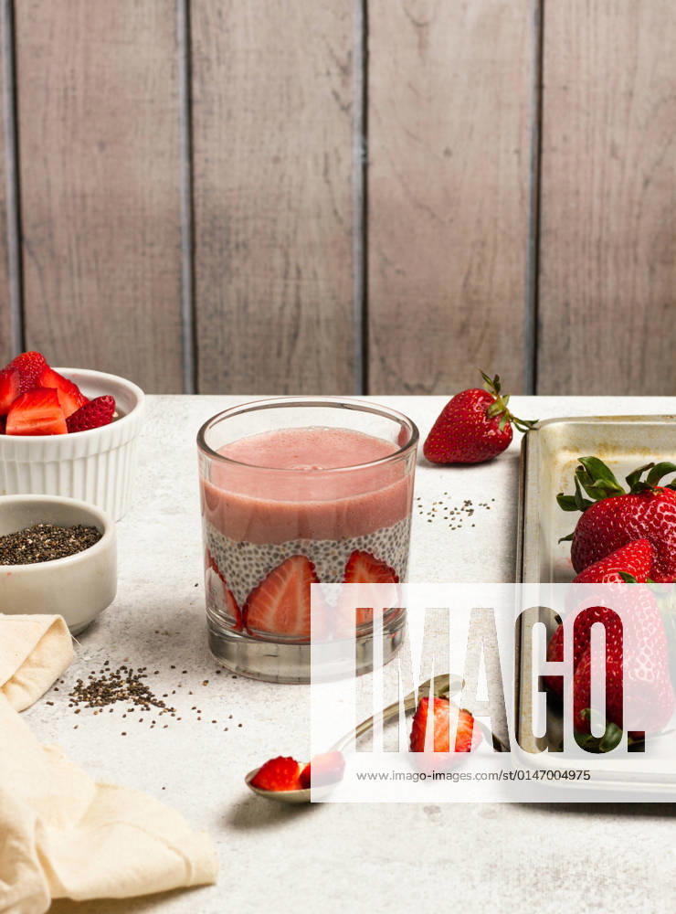 Tasty pudding with chia seeds and slices of fresh strawberries placed on table near ingredients for healthy breakfast NadiaSapollnik_ChiaFruit_1.jpg