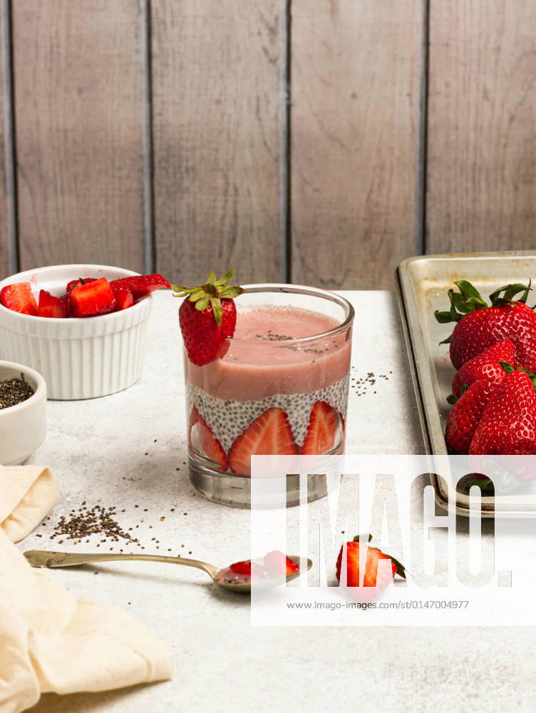 Tasty pudding with chia seeds and slices of fresh strawberries placed on table near ingredients for healthy breakfast NadiaSapollnik_ChiaFruit_3.jpg