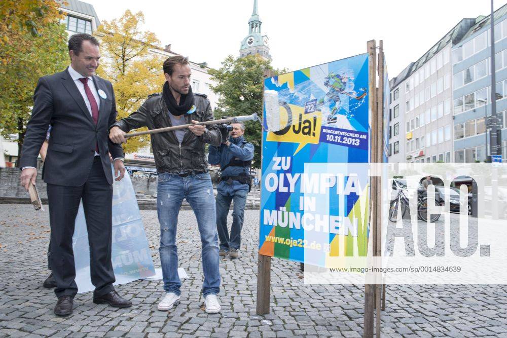 Plakataktion Buergerbegehren pro Olympia 2022, Rindermarkt, München. 22.12.2013 Thomas Muderlak, der Geschäftsführer der BMW Welt, Vorstandssprecher der Tourismus Initiative München, Mitbegründer des Team München 2022 und Sven Hannawald, Skispringer und Rennfahrer kleben Plakate Â