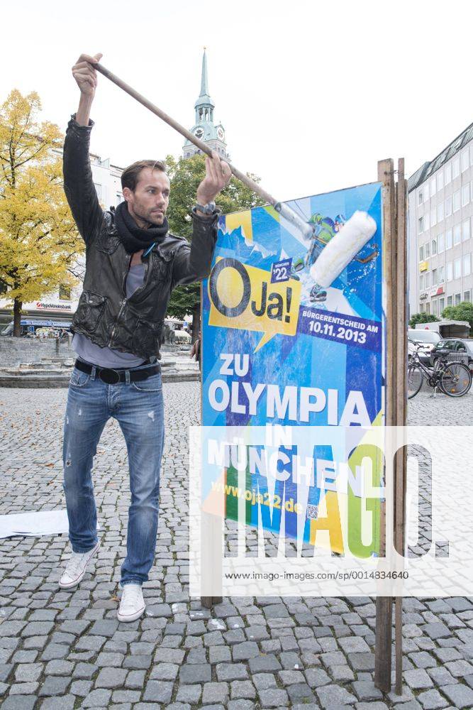 Plakataktion Buergerbegehren pro Olympia 2022, Rindermarkt, München. 22.12.2013 Thomas Muderlak, der Geschäftsführer der BMW Welt, Vorstandssprecher der Tourismus Initiative München, Mitbegründer des Team München 2022 und Sven Hannawald, Skispringer und Rennfahrer kleben Plakate Â