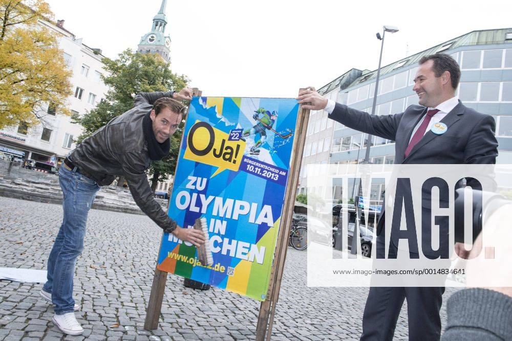 Plakataktion Buergerbegehren pro Olympia 2022, Rindermarkt, München. 22.12.2013 Thomas Muderlak, der Geschäftsführer der BMW Welt, Vorstandssprecher der Tourismus Initiative München, Mitbegründer des Team München 2022 und Sven Hannawald, Skispringer und Rennfahrer kleben Plakate Â