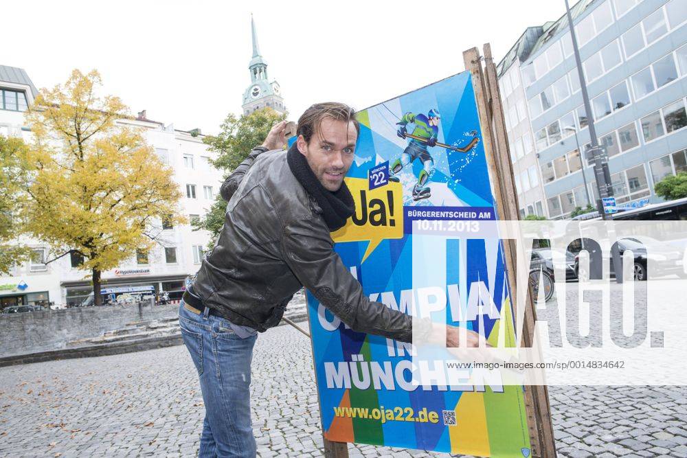 Plakataktion Buergerbegehren pro Olympia 2022, Rindermarkt, München. 22.12.2013 Thomas Muderlak, der Geschäftsführer der BMW Welt, Vorstandssprecher der Tourismus Initiative München, Mitbegründer des Team München 2022 und Sven Hannawald, Skispringer und Rennfahrer kleben Plakate Â