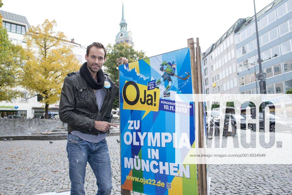 Plakataktion Buergerbegehren pro Olympia 2022, Rindermarkt, München. 22.12.2013 Thomas Muderlak, der Geschäftsführer der BMW Welt, Vorstandssprecher der Tourismus Initiative München, Mitbegründer des Team München 2022 und Sven Hannawald, Skispringer und Rennfahrer kleben Plakate Â