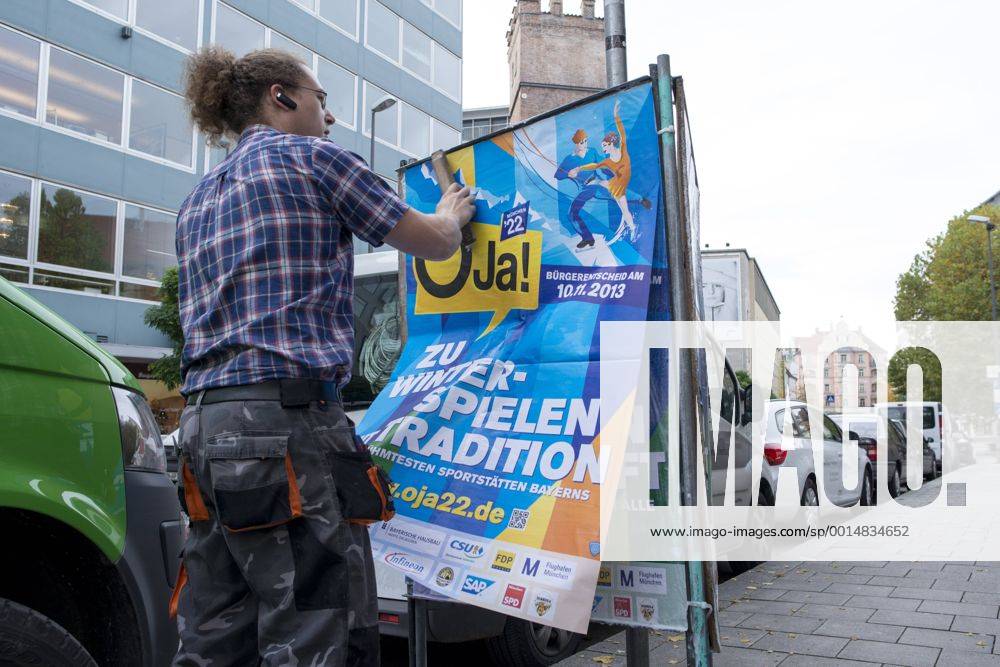 Plakataktion Buergerbegehren pro Olympia 2022, Rindermarkt, München. 22.12.2013 Thomas Muderlak, der Geschäftsführer der BMW Welt, Vorstandssprecher der Tourismus Initiative München, Mitbegründer des Team München 2022 und Sven Hannawald, Skispringer und Rennfahrer kleben Plakate Â