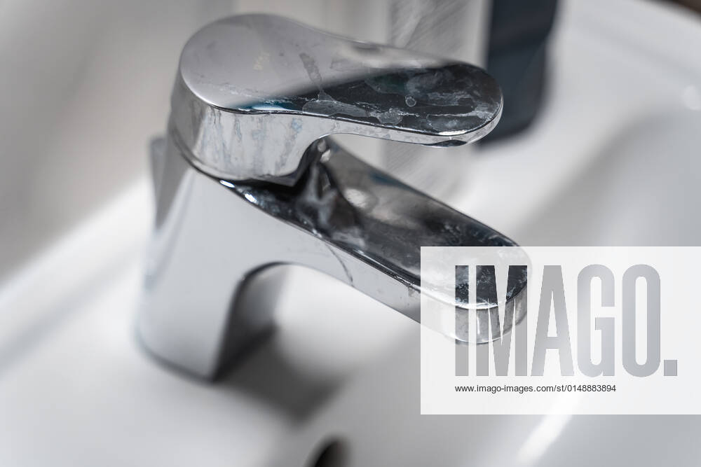 Germany - 25 January 2022: bathroom faucet full of lime, contaminated sink