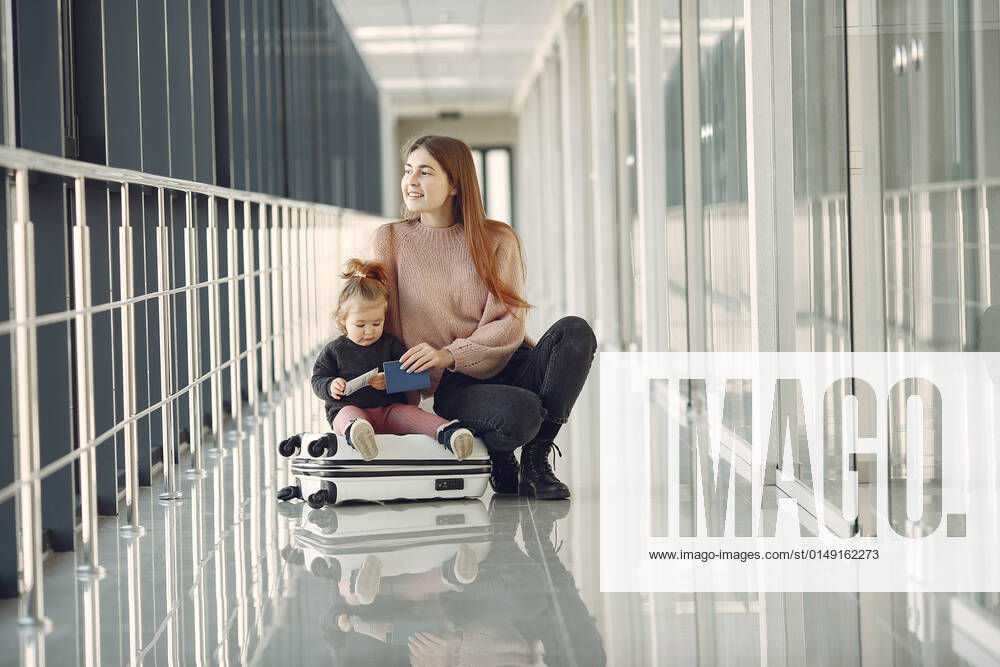 Mother with daughter at the airport Family at the airport. Mother with daughter. Woman with suitcase.