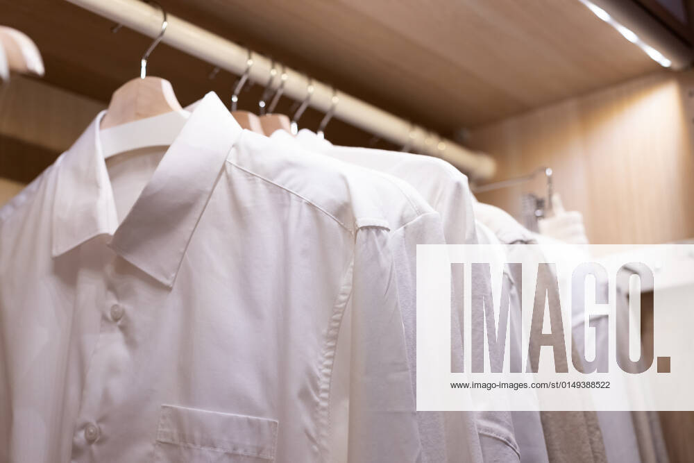 Clothes on a rail in a wardrobe. Seasonal capsule for easy dressing, order in things, cleaning out.Colorful casual clothes hang on hangers.Wardrobe, dressing room filled with clothes, shoes. storage Clothes on a rail in a wardrobe. Seasonal capsule for easy dressing, order in things, cleaning out