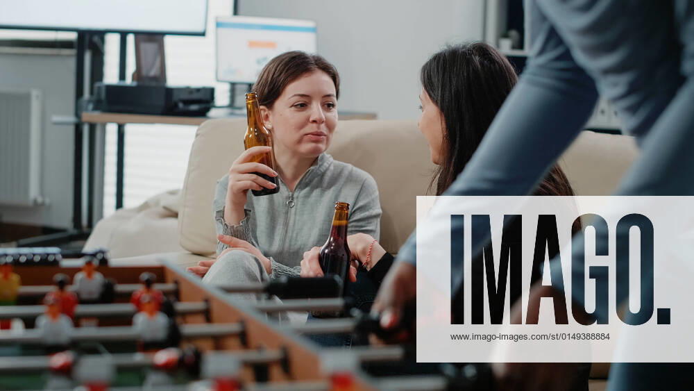 Close up of women with bottles of beer and snacks talking Close up of women with bottles of beer and snacks talking at office after work. Colleagues enjoying free time with alcoholic beverage to do fun activity with entertainment after hours