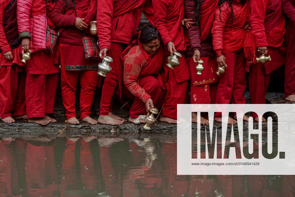 Devotees fills water from the Bagmati River, which is considered by them to be holy, during the Swasthani Brata Katha festival in Kathmandu, Nepal. Bhaktapur Nepal - ZUMAm204 20220201_zip_m204_006