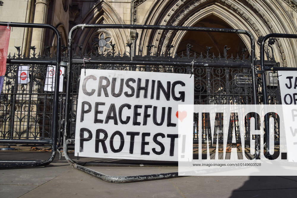 Crushing Peaceful Protest placard is seen during the protest outside the Royal Courts of Justice..19 Insulate Britain activists are on trial for breaking the M25 injunction. Four activists skipped their hearing and glued themselves to the steps at the entrance to the courts. Insulate Britain are demanding that the government ensures that all homes in the UK are more energy-efficient by 2030. London United Kingdom - ZUMAs197 20220201_zaa_s197_128