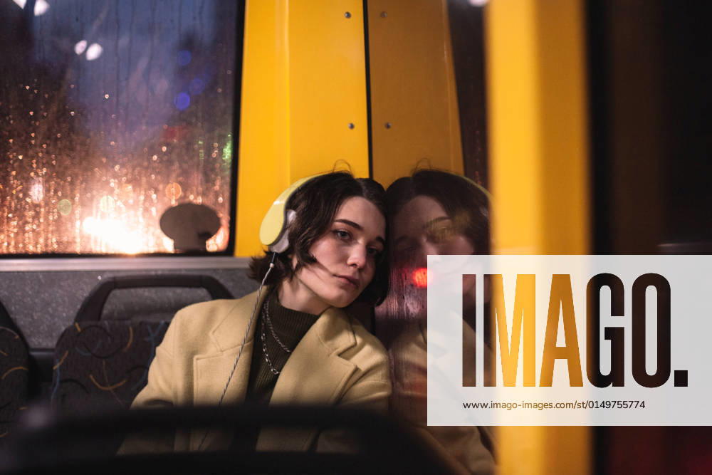 Young woman looking through window traveling in trolley bus CR_DMBE220203-885855-01 ,model released, Symbolfoto