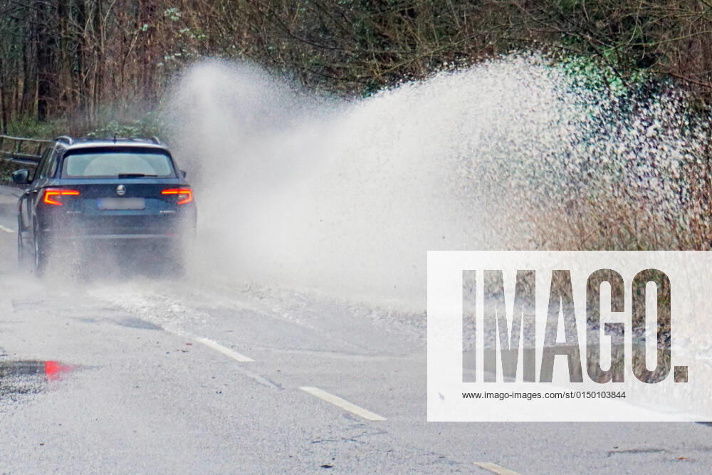 Gefährliche Straßenverhältnisse bei Starkregen Das Wasser von einer nach Starkregen überfluteten Straße wird von den Autos in die Luft gerissen und sorgt bei vielen Fahrern für Schrecksekunden. Essen Nordrhein-Westfalen Deutschland L191