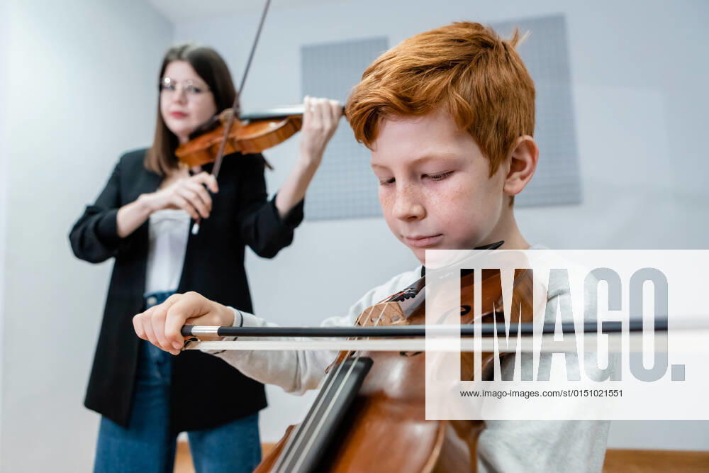 IMAGO Creative: Bildung, Musikerziehung Female teacher and boy playing violins during lesson in modern music school, Model released, Property released OlgaGuardon_MusicSchool_23.jpg