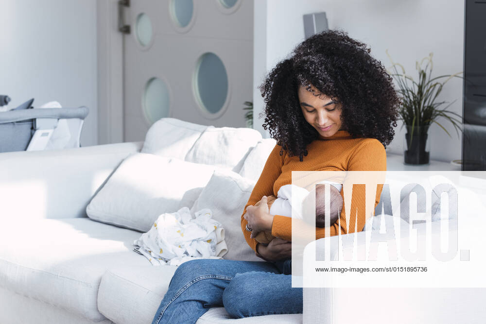 Mother breastfeeding and looking at son in living room model released property released, PNAF03174
