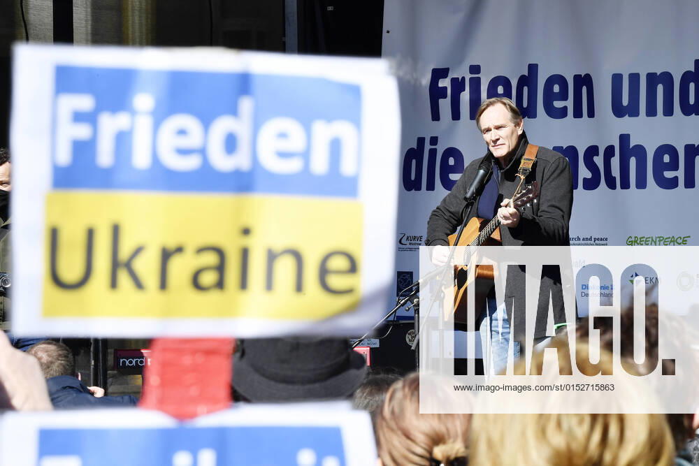 Demonstration Peace and solidarity for the people in Ukraine in Leipzig 13 03 2022 Leipzigs mayor Burkhard Jung at the demonstration against the war in Ukraine in Leipzig 13 03 2022 with a guitar in front of a sign Peace and solidarity for the people in Ukraine Stop the war In the foreground in sign with the i