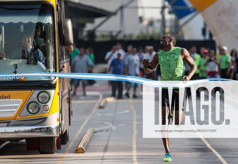 The Jamaican record-holder Usain Bolt (R) crosses the finish line after beating a bus in a race in the 9 de Julio Avenue, in Buenos Aires, Argentina, on Dec. 14, 2013. Bolt performed different activities during his visit to Argentina with a talk about leadership, sporting clinics to kids in poverty and a race of 80 meters against a bus in the 9 de julio Avenue. (Xinhua Martin Zabala) (rt) (SP)ARGENTINA-BUENOS AIRES-ATHLETICS-USAIN BOLT