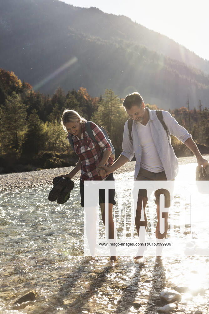 Austria, Alps, couple on a hiking trip wading in a brook model released, UUF16539