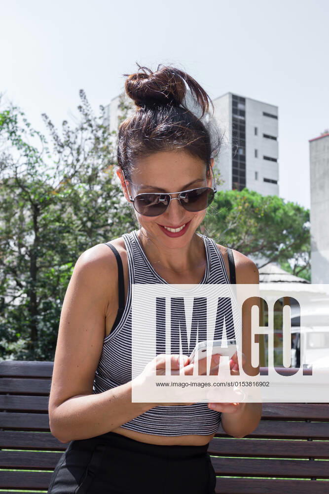 Young brunette woman, sitting on a bench in the park with mobile phone., model released, , property released, , 33358984.jpg, attractive, beautiful, bench, black, brunette, bun, caucasian, cellphone, communication, female, girl, glasses, hair, happy, lifestyle, looking, messy, mobile, outdoors, park, phone, portrait, pretty, sitting, smartphone, smile, summer, sun, technology, text, texting, using, white, woman, young
