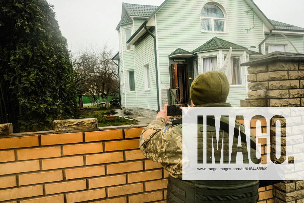 A Ukrainian soldier takes photographs of dead civilians in a yard in Bucha, a suburb of the capital city of Kyiv. As Russian troops withdraw from areas north of Ukraine s capital city of Kyiv Ukrainian officials call the heavy civilian casualties found dead in the city of Bucha a deliberate war crime, sparking International condemnation. Kyiv Ukraine - ZUMAs197 20220403_zaa_s197_207