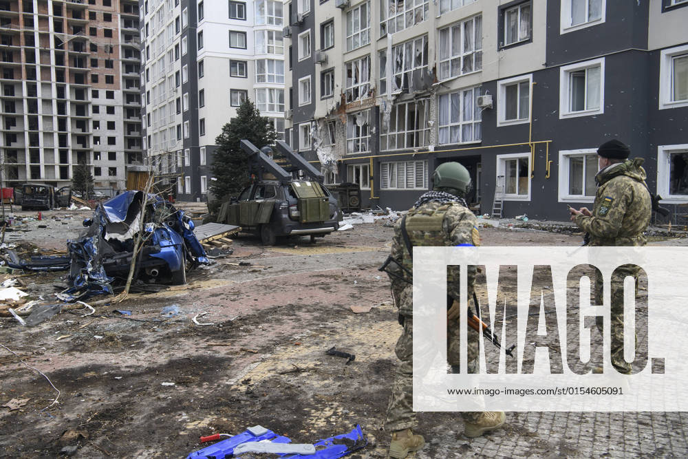Ukraine-Krieg, Jahrestag der Invasion, Chronologie der Ereignisse, Archivbilder Ukraine-Konflikt, Eindrücke aus Butscha Situation In The Recaptured By The Ukrainian Army Bucha City Near Kyiv, Ukraine Ukrainian servicemen stands near Destroyed civil vehicles near a damaged residential building in the recaptured by the Ukrainian army Bucha city near Kyiv, Ukraine, 04 April 2022. Bucha Ukraine