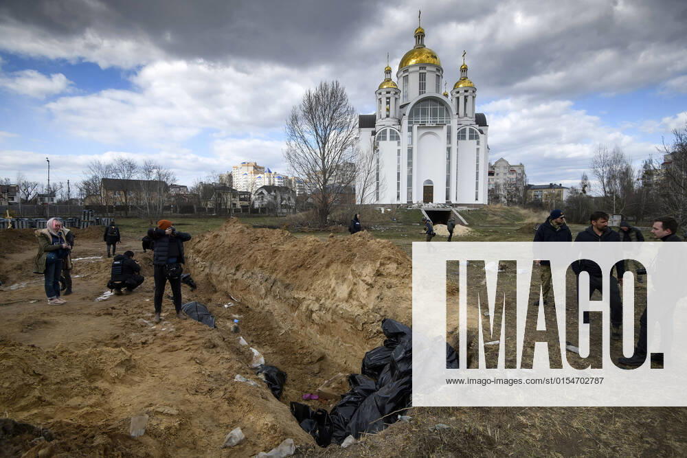 A mass grave is seen behind a church in the town of Bucha, northwest of the Ukrainian capital Kyiv, on Monday. April 4, 2022. Ukraine and Western nations accused Russian troops of war crimes after the discovery of the mass graves and civilians who were apparently executed near Kyiv,. One rescue official said 57 people were found in one hastily dug trench behind a church. KYV2022040501 VladyslavxMusienko