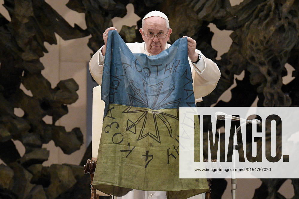 Italy, Rome, Vatican, 2022 04 06.Pope Francis shows a flag that he said was sent to him from Bucha, Ukraine, during his weekly general audience in the Paul VI Hall, at the Vatican. Photograph by Vatican media Catholic Press Photo RESTRICTED TO EDITORIAL USE - NO MARKETING - NO ADVERTISING CAMPAIGNS.