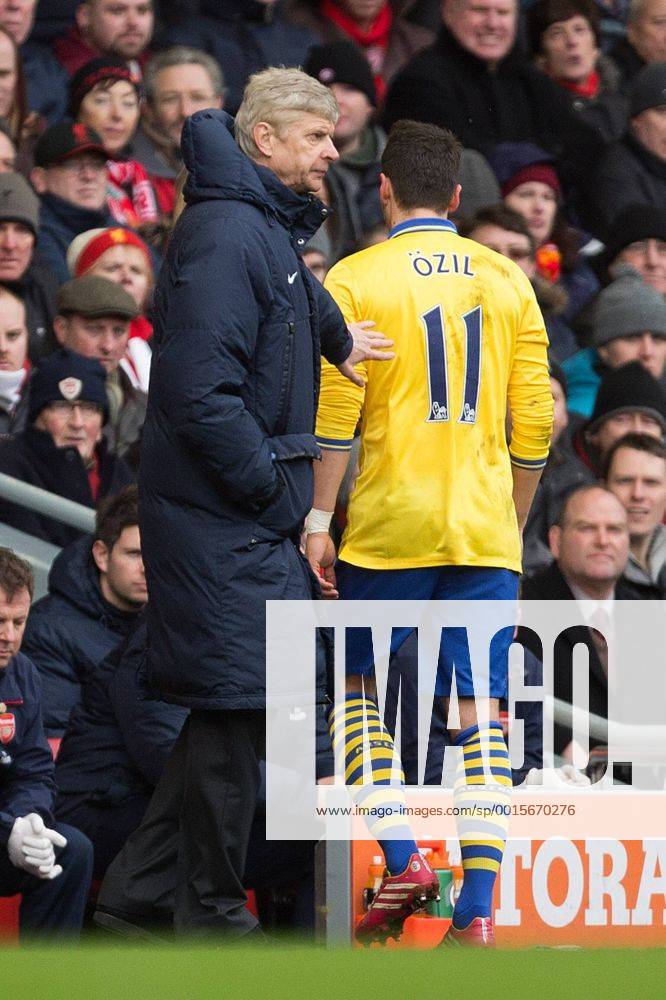 Arsenal s manager, Arsene Wenger pats Mesut Ozil on the back following his substitution - Liverpool vs. Arsenal - Barclays Premier League - Anfield - Liverpool - 08 02 2014 Pic Philip Oldham Sportimage .