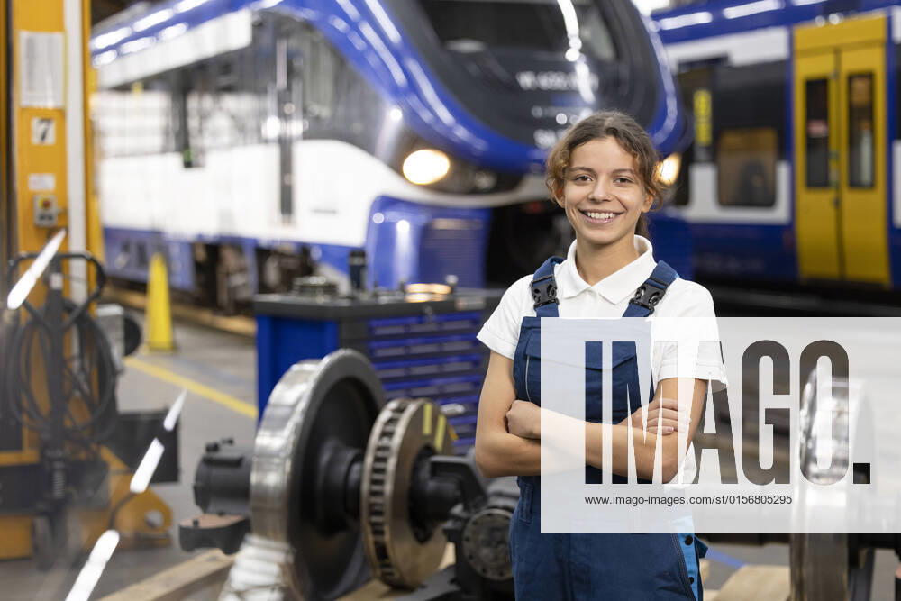 IMAGO Creative: Business, Inflation und Lieferketten Smiling young trainee standing with arms crossed in warehouse at factory model released, Symbolfoto property released, FKF04799