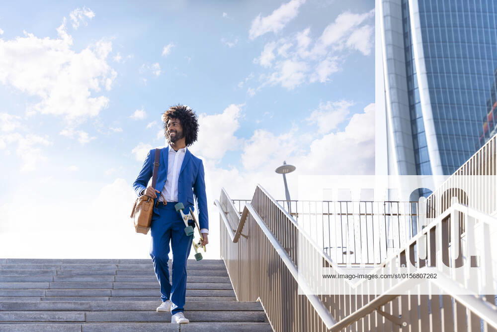 Smiling businessman with skateboard walking down on staircase model released, Symbolfoto, OIPF01457