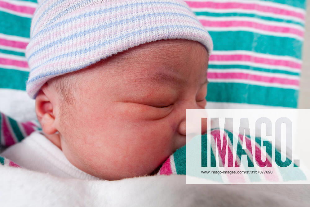 Cute face of a innocent newborn baby with eyes closed, wearing a unisex hat, laying on white with green and pink sheets asleep., model released, , 489886.jpg, white, green, pink, hat, unisex, male, female, girl, boy, baby, newborn, neonate, cute, beauty, innocence, innocent, lay, laying, asleep, sleeping, sleep, child, Caucasian,