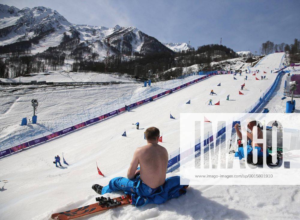 Feb. 22, 2014 - Sochi, RUS - Course workers take their shirts off to enjoy warm weather during the snowboard parallel slalom competition at the Rosa Khutor Extreme Park during the Winter Olympics in Sochi, Russia, Saturday, Feb. 22, 2014. Parallel Slalom Snowboarding - ZUMAm67