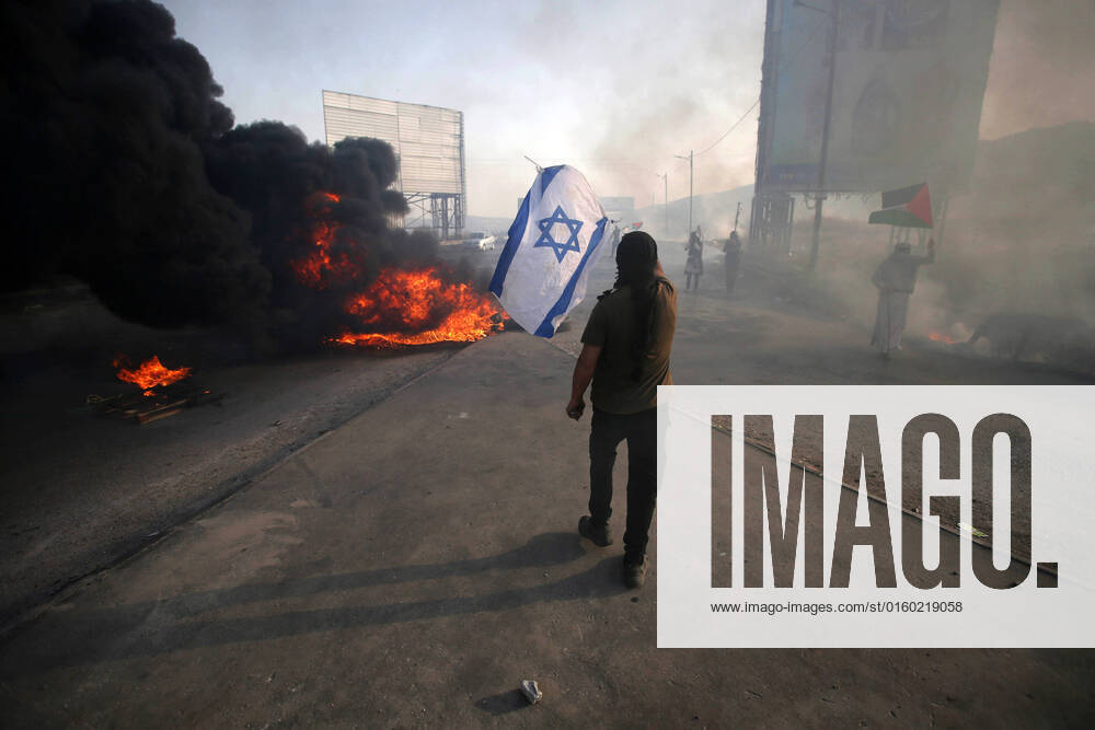 Nablus, West Bank, Palestinian Territory: Palestinian protesters clash with Israeli troops following a demonstration to denounce the annual nationalist flag march through Jerusalem, at the Israeli-controlled Hawara checkpoint near Nablus in the West Bank on May 29, 2022. Thousands of Israelis started the annual nationalist flag march through Jerusalem that regularly stokes Palestinian anger, a year after tensions in the disputed Holy City exploded into war. Some 3,000 police were deployed for the event that marks Israel s 1967 capture of east Jerusalem, home of the Al-Aqsa mosque compound located on what Jews revere as the Temple Mount Nablus Palestinian Territory - ZUMAap3_ 20220529_zaf_ap3_305