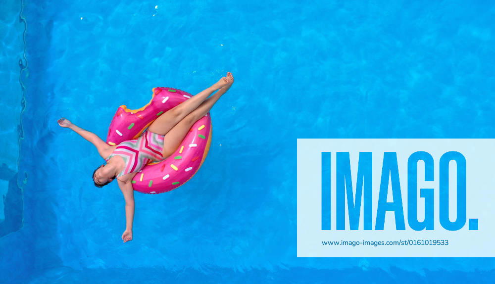 The own swimming pool in the garden provides refreshment in the summer in the next days of June heat wave Aerial view of a garden pool in Unterallgäu teenager sunbathing on a swimming tire in the water Modelreleased 15 06 2022, Swimming pool in your own garden 15 06 2022, Swimming pool in your own garden