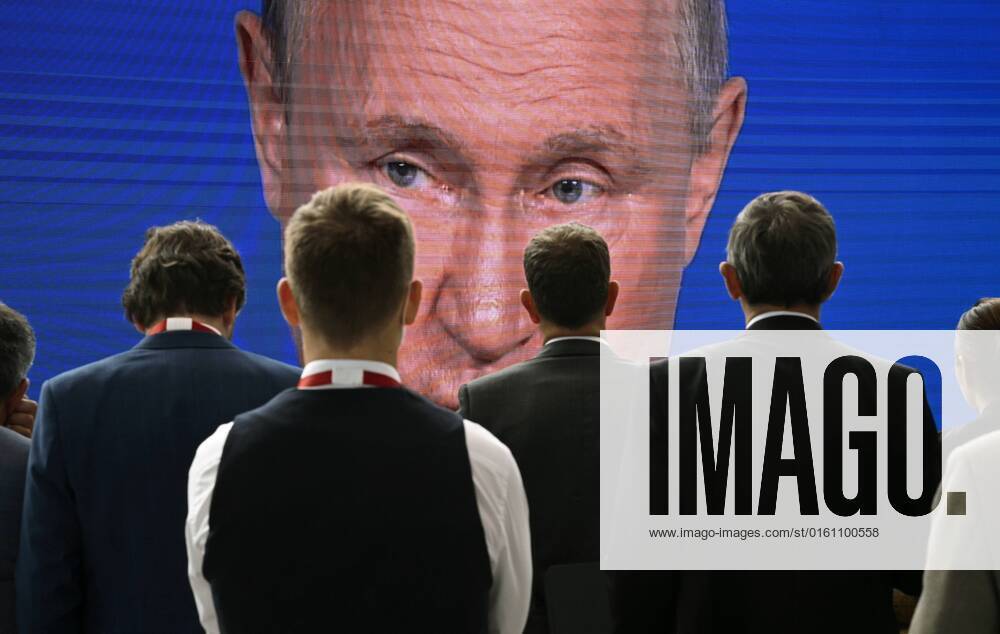 Russia SPIEF Putin Broadcast 8218440 17.06.2022 Participants gather near a screen showing Russian President Vladimir Putin delivering a speech during a plenary session of the 25th St. Petersburg International Economic Forum (SPIEF) in Saint Petersburg, Russia. Grigory Sysoev Sputnik St. Petersburg Russia