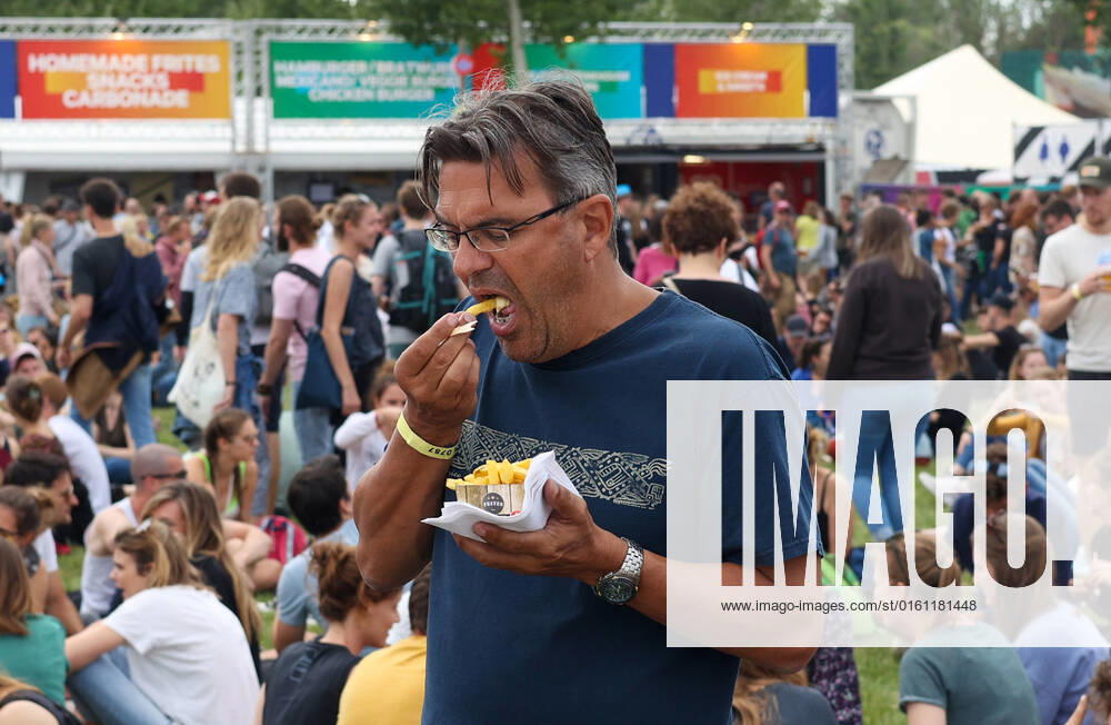 Illustration picture shows a festival goer with a packet of frites (frietjes, frieten, fries) at the one-day Werchter Boutique festival, in Werchter, on Friday 18 June 2021. VIRGINIExLEFOUR 36482082
