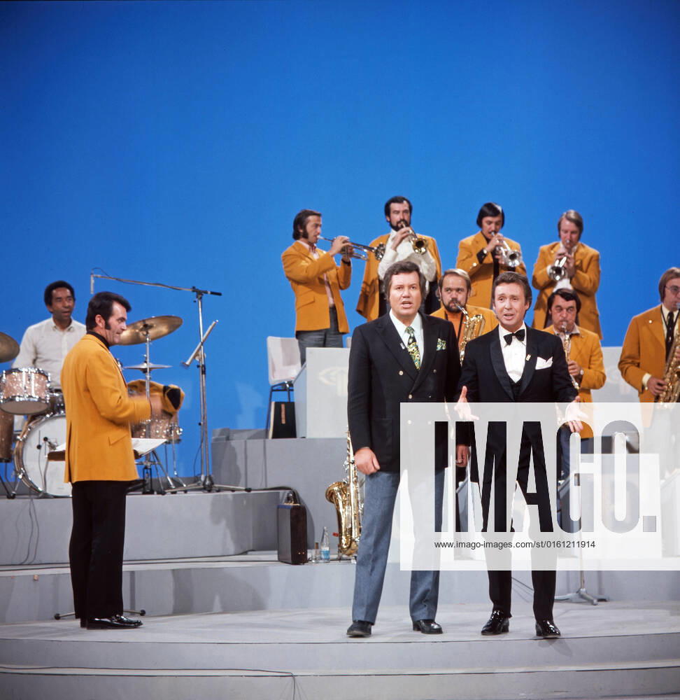 DREI MAL NEUN Drei mal Neun, ZDF Quizshow, Deutschland, 1971, im Bild: Bandleader Max Greger mit Bigband, Showmaster Wim Thoelke und Showgast Peter Alexander bei einer heiteren Showdarbietung. Drei mal Neun, TV quiz show, Germany, 1971, on the photo: Bandleader Max Greger with big band, presenter Wim Thoelke and show guest Peter Alexander with a cheerful show performance., Deutschland