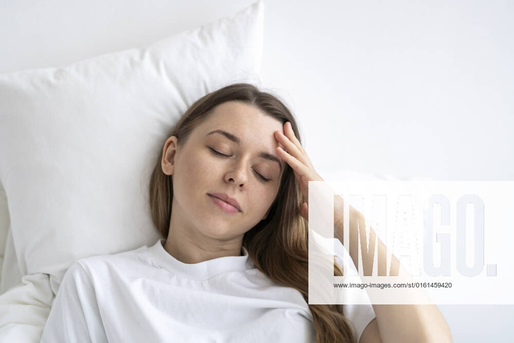 Tired woman with eyes closed lying on bed at home model released, Symbolfoto property released, SSGF00933