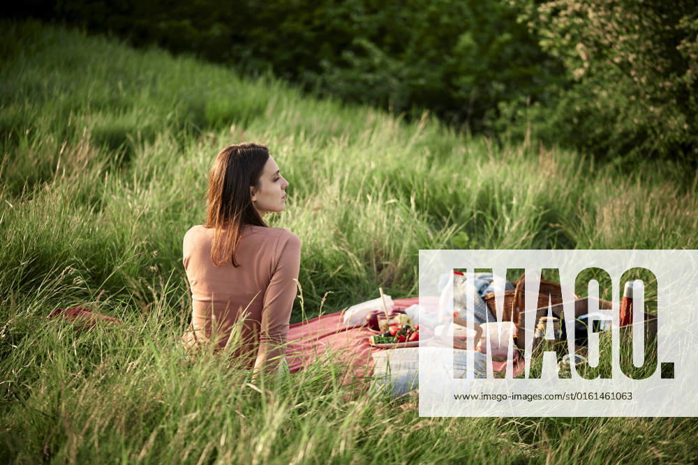 Contemplative woman sitting in field on weekend model released, Symbolfoto, ZEDF04589
