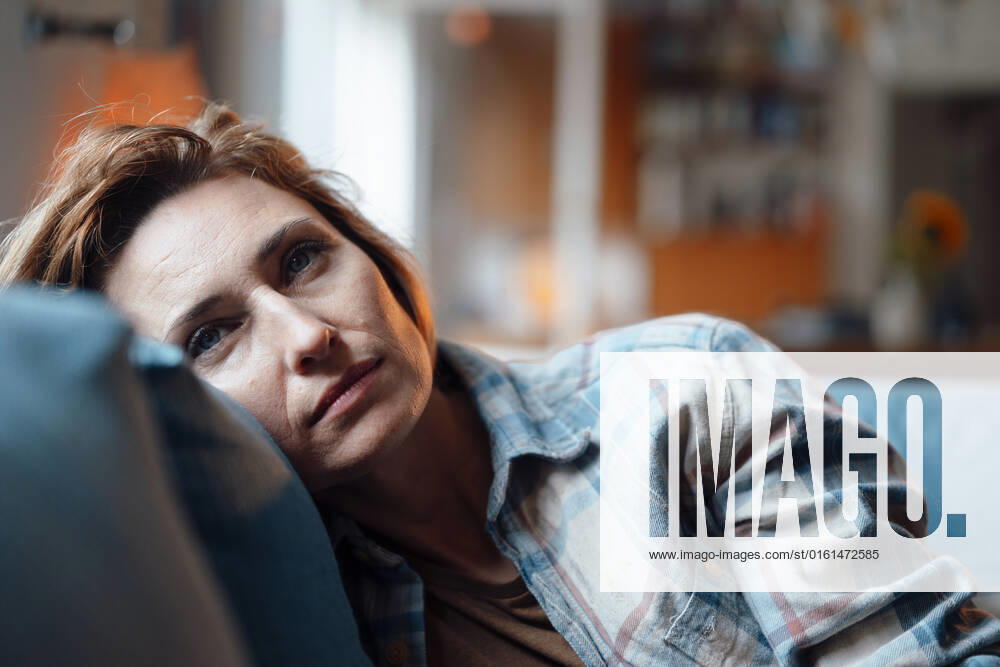 Thoughtful woman leaning on sofa in living room at home model released, Symbolfoto property released, JOSEF10334