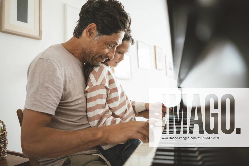 IMAGO Creative: Bildung, Musikerziehung Happy father teaching piano to daughter at home model released, Symbolfoto property released, JOSEF10432