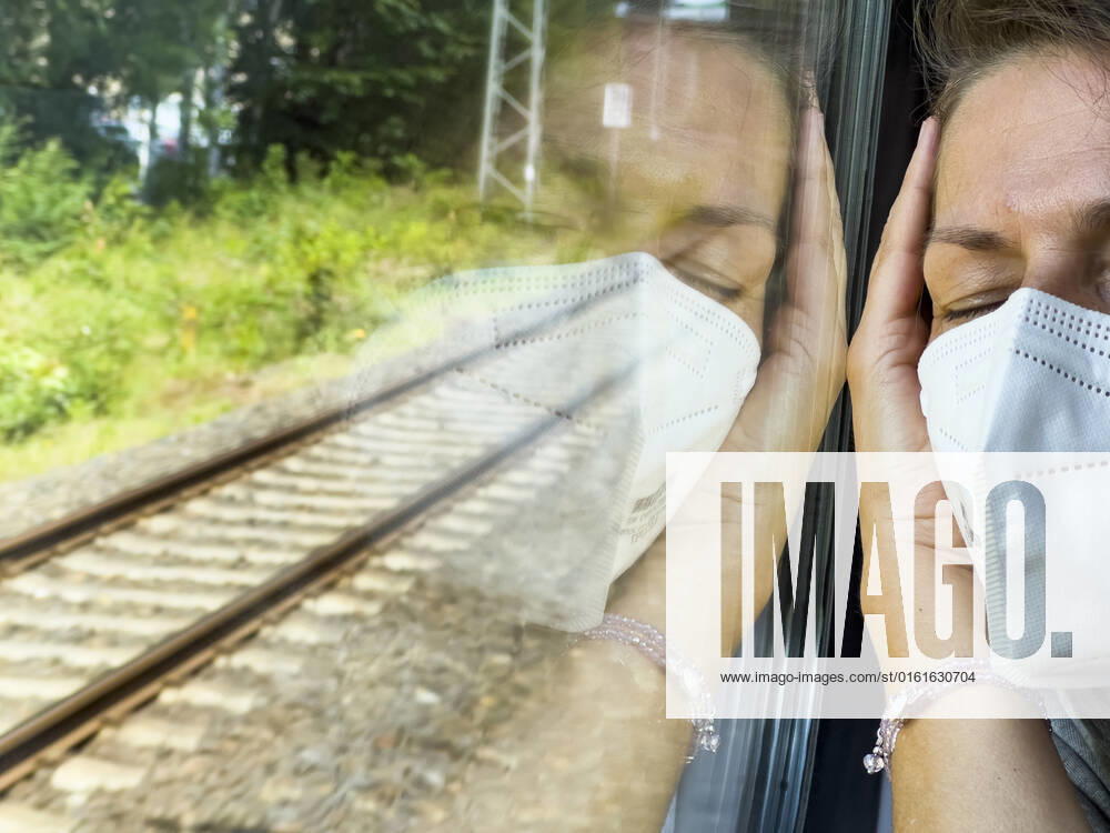 Person sleeping in an DB ICE train with Corona mouth and nose protection on Juni 23, 2022 in Hamburg, Germany.