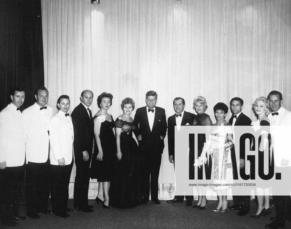 White House News Photographers Association (WHNPA) Dinner, 7:37PM. President John F. Kennedy poses with performers at the White House News Photographers Association (WHNPA) dinner. L-R: five unidentified persons; actress, Shelley Winters; President Kennedy; comedian and Master of Ceremonies, Alan King; singer, Jane Morgan; dancers, Margo Rodr u1f77guez and Augie Rodr u1f77guez; unidentified; musician, Chet Atkins. Sheraton Park Hotel, Washington, D.C.