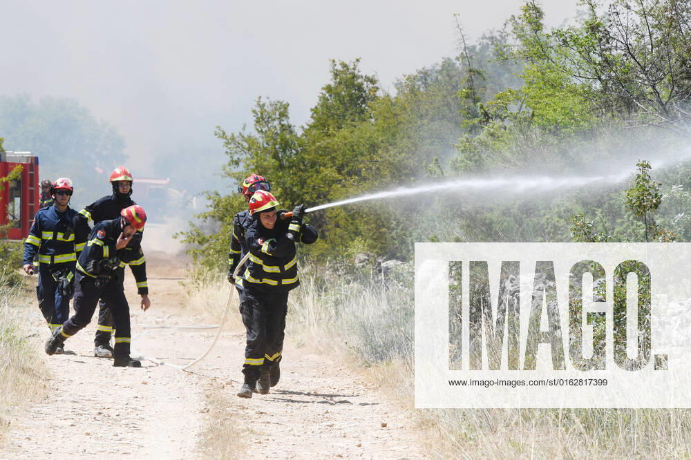 PXL_A fire near Vodice, Croatia Fire in an open area near the Velika Mrdakovica archaeological site in the Vodice hinterland, Croatia on July 13, 2022. About 30 firefighters with a dozen vehicles are on the ground, and two Canadairs joined the ground forces in extinguishing the fire. There are pine forests above, low vegetation, and endangered buildings. HrvojexJelavic PIXSELL