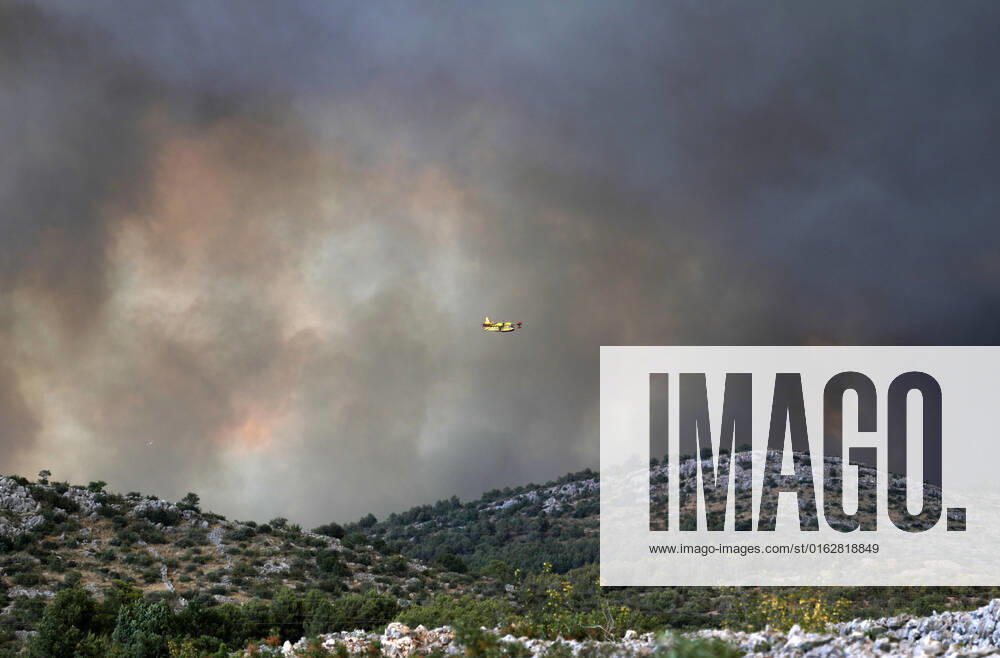 PXL_A fire near Zaton, Croatia Fire in an open area near the Zaton site in the Vodice hinterland, Croatia on July 13, 2022. About 30 firefighters with a dozen vehicles are on the ground, and two Canadairs joined the ground forces in extinguishing the fire. There are pine forests above, low vegetation, and endangered buildings. DuskoxJaramaz PIXSELL