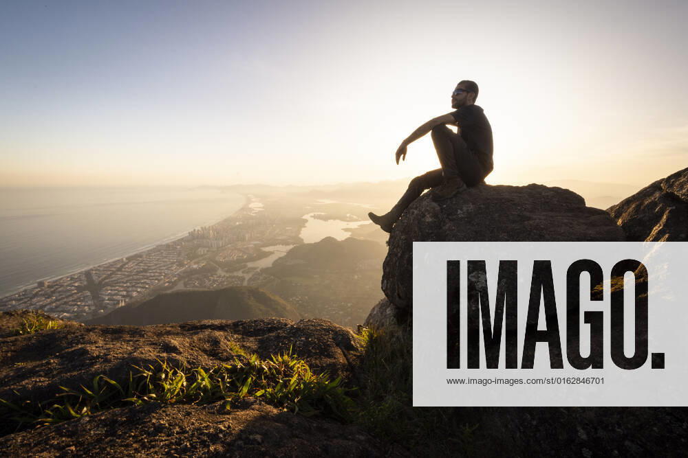 Man enjoying beautiful sunset view to city from rocky mountain top Rio de Janeiro, State of Rio de Janeiro, Brazil CR_GNUJ22070662-1004291-01 ,model released, Symbolfoto