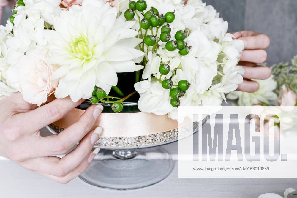 Florist at work. How to make floral decorations for summer party table. Centerpiece with rose, dahlia and hortensia flowers. Step by step, diy. BEW1D9D1352
