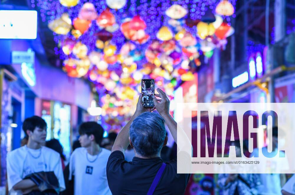 (220723) -- GUIYANG, July 23, 2022 -- A visitor takes photos of a local market at the Qingyun Road in Nanming District of Guiyang, capital city of southwest China s Guizhou Province, July 21, 2022. Qingyun Road was a famous bustling food street at nighttime in the city of Guiyang. Thanks to local planning and years of renovation, the road has turned to be a popular commercial pedestrian street which contains various trendy businesses like cultural innovation and art design while retaining its food street fame. ) CHINA-GUIZHOU-GUIYANG-NIGHT ECONOMY (CN) YangxWenbin